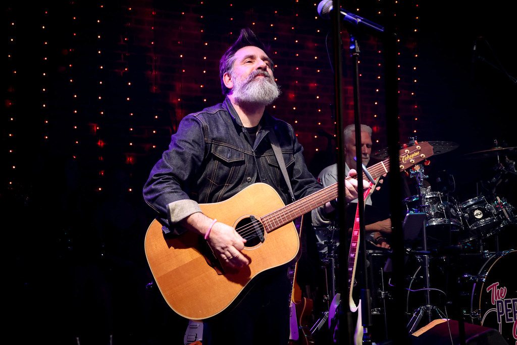 Nick Robinson playing an acoustic guitar on stage